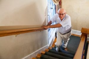 Senior man (80s) climbing staircase.